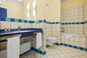 a bathroom with a toilet and a sink at Neptun Hotel Kühlungsborn in Kühlungsborn +39 photos