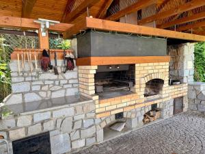 an outdoor brick oven with a wooden roof at Vila Bělá pod Pradědem in Bělá pod Pradědem