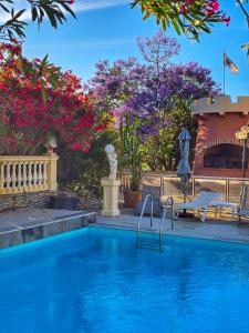 a swimming pool in a garden with flowers at Castellu Rossu in Lucciana