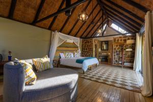 a bedroom with two beds and a couch in a room at Masuwe Lodge in Victoria Falls +32 photos