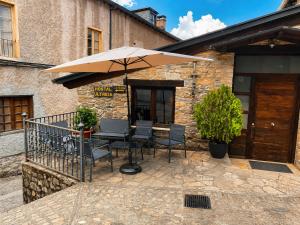 a table and chairs under an umbrella on a patio at Hostal Ultreia in Villafranca del Bierzo