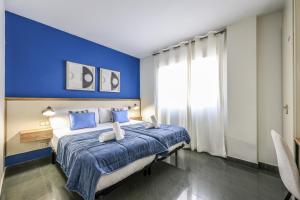 a blue bedroom with a king sized bed with blue walls at UP Hotel Velilla in Velilla de San Antonio
