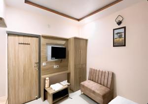 a room with a tv and a chair and a door at Hotel Ganga Ram in Chitrakoot +9 photos