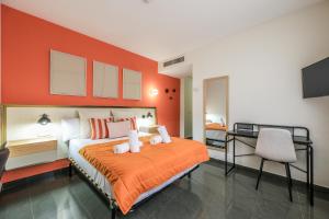 a bedroom with a bed with an orange wall at UP Hotel Velilla in Velilla de San Antonio