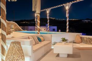 a living room with a couch and a pool at night at Silia Dream View in Houlakia