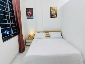 a bedroom with a white bed and a window at Harmony Apartment in Hanoi +6 photos