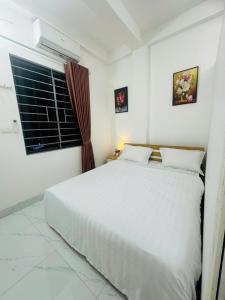a bedroom with a white bed and a window at Harmony Apartment in Hanoi