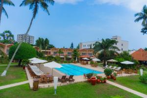 ein Resort mit Pool, Liegestühlen und Palmen in der Unterkunft Hôtel Elaïs in Pointe-Noire