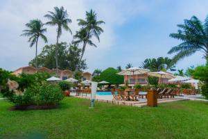 ein Resort mit Pool, Tischen und Sonnenschirmen in der Unterkunft Hôtel Elaïs in Pointe-Noire