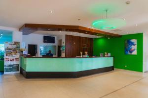 eine grüne Akzentwand in einem Restaurant mit Theke in der Unterkunft Hôtel Elaïs in Pointe-Noire + 46 Fotos