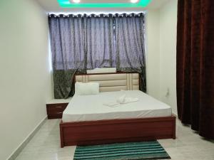 a bedroom with a bed and a window with curtains at Hotel Raj in Letekujān +5 photos