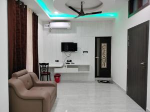 a living room with a couch and a tv on the ceiling at Hotel Raj in Letekujān