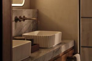a bathroom with a white sink on a counter at Rosewood AMAALA in Amala