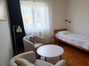 a small room with a bed and a table and chairs at Vila Flori in Koper
