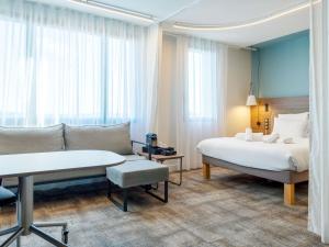 a hotel room with a bed and a couch at Novotel Suites Nancy Centre in Nancy