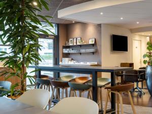 a bar in a restaurant with stools at Novotel Suites Nancy Centre in Nancy