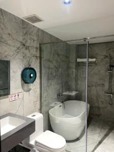 a bathroom with a toilet and a tub and a sink at Khách Sạn Phượng Vĩ in Cà Mau +34 photos