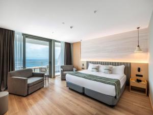 a hotel room with a bed and a chair at Korumar Hotel Deluxe in Kuşadası +74 photos