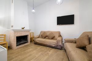 a living room with a couch and a fireplace at Yerbaluisa in Laroya