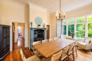 a dining room with a large wooden table and chairs at Crescent Villa - Stay Waiheke in Ostend