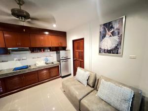 a living room with a couch and a kitchen at Bungalow Apartment Kamala in Phuket