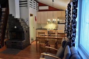 a kitchen and dining room with a table and a fireplace at Polar Star Apartments in Levi