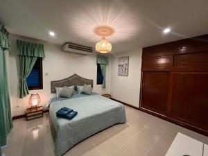a bedroom with a large bed and a cabinet at Bungalow Apartment Kamala in Phuket