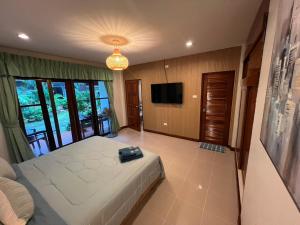 a large bedroom with a bed and a television at Bungalow Apartment Kamala in Phuket