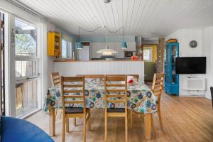 a dining room with a table and chairs and a tv at 136-Snedsted-Lykkens-Hab-23 in Snedsted