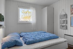 a bed with blue pillows sitting in a room at 136-Snedsted-Lykkens-Hab-23 in Snedsted