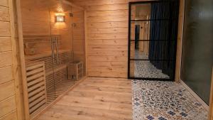 a room with a sauna with wooden walls and wooden floors at Domek SPA z sauną i jacuzzi - Level780 in Koszarawa