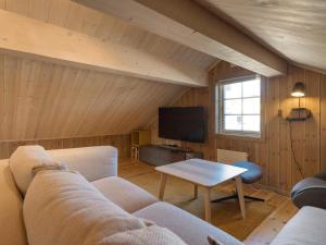 a living room with a couch and a tv at Ski cabin in Hafjell in Øyer