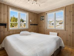 a bedroom with a bed and two windows at Ski cabin in Hafjell in Øyer