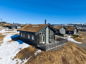 a house with a roof on a field with snow at Ski cabin in Hafjell in Øyer