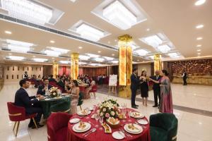 a group of people sitting at tables in a banquet hall at FabHotel Prime The Ballroom - Near GD Goenka University in Gurgaon