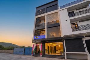a building with a store front with the sunset in the background at FabHotel Prime The Ballroom - Near GD Goenka University in Gurgaon