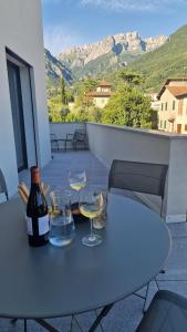 a table with glasses and a bottle of wine on a balcony at Lake Como Terrace Suite in Mandello del Lario +17 photos