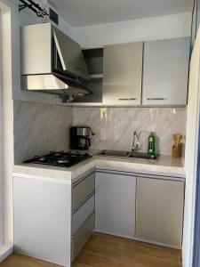 a kitchen with white cabinets and a stove at sunsetvilla studio in Saint-Martin