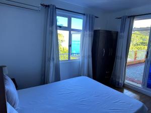 a bedroom with a bed and a large window at sunsetvilla studio in Saint-Martin