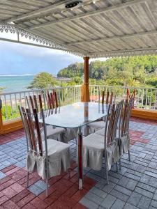 a table and chairs on a balcony with the ocean at sunsetvilla studio in Saint-Martin