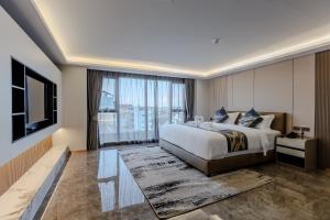 a bedroom with a large bed and a large window at Marquis Hotel in Ban Bang Toei (1)