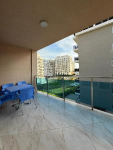 a balcony with a blue table and chairs on a building at Elois Apartments in Shëngjin