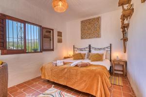 a bedroom with a bed with orange sheets and windows at Casa Azafranes - Boutique B&B - Arenas in Arenas +144 photos
