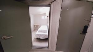 a small room with a bed and a glass door at 1971 Sinpung Inn in Seoul +26 photos