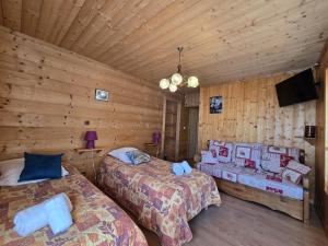 a bedroom with two beds in a log cabin at Les Touristes in Abondance