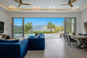 a living room with blue couches and a table and chairs at The Palm Oasis in Lamai