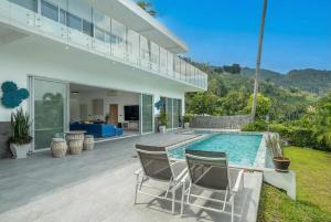 a house with a swimming pool and two chairs at The Palm Oasis in Lamai