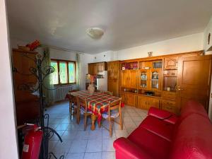 a living room with a table and a red couch at Da Gabriele è vacanza in Gubbio +11 photos
