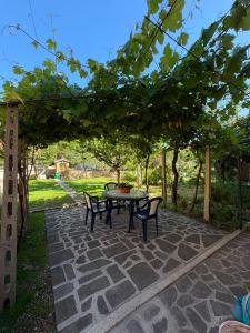 a patio with a table and chairs under a tree at Da Gabriele è vacanza in Gubbio