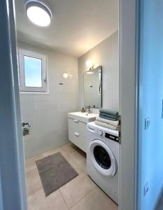 a bathroom with a washing machine and a sink at Villa Peony Koroni in Koroni